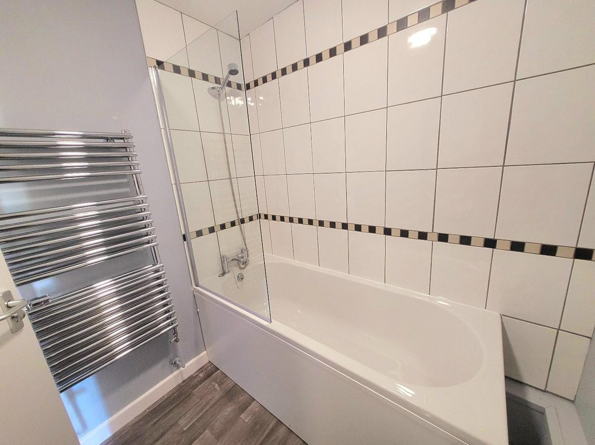 Clean, tiled bathrooms with bath and shower, maintained as part of the housing management package.